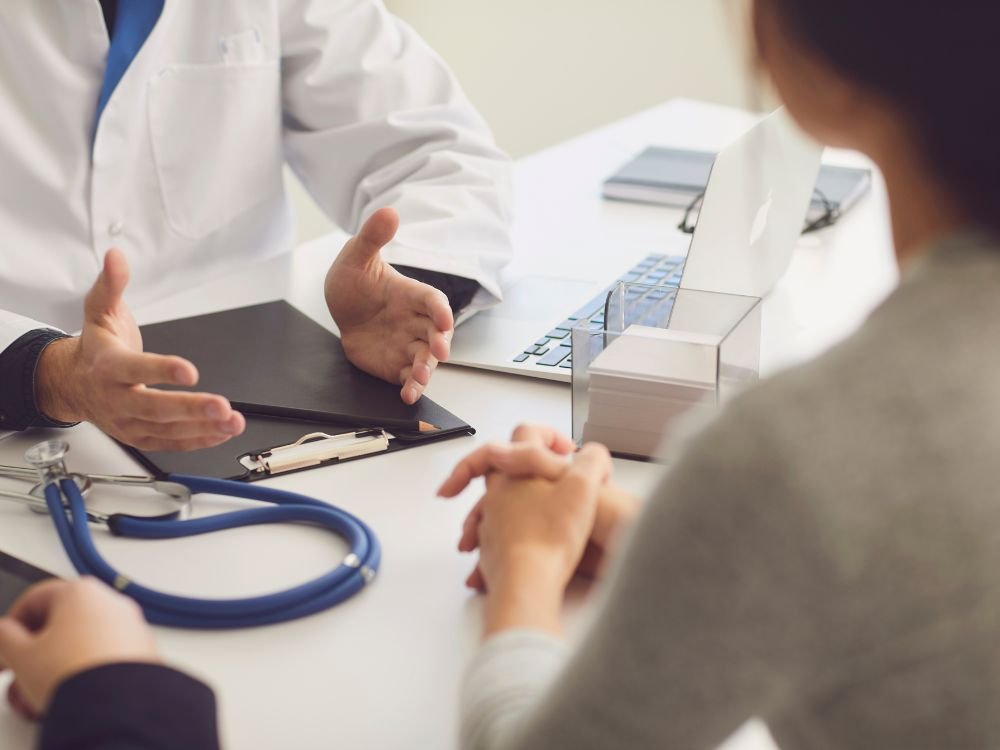 Consulta médica com paciente em avaliação clínica para investigar sintomas gastrointestinais relacionados às fezes amarelas.