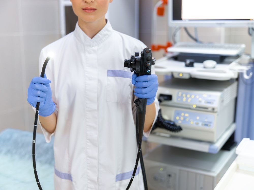 Médicos realizando exame com monitor ligado, destacando o ambiente controlado e o rigor técnico do preparatório para endoscopia.