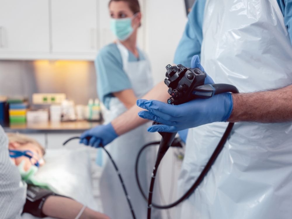 Profissionais de saúde em ambiente hospitalar com equipamentos médicos, ilustrando a importância do preparatório para endoscopia seguro e preciso.