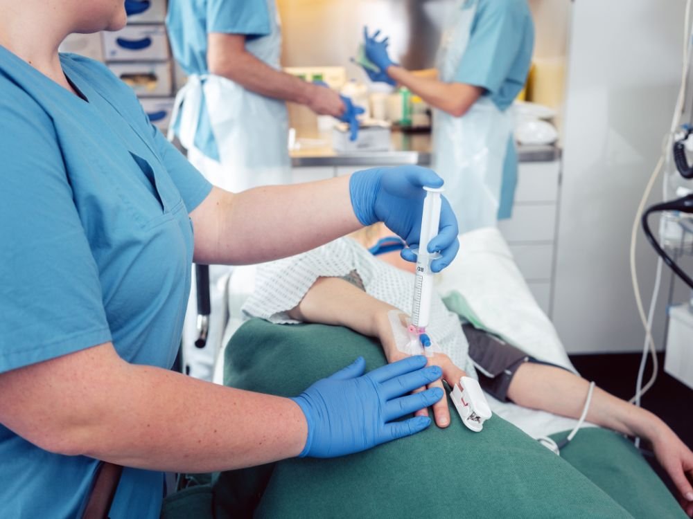 Aplicação de sedação venosa em paciente antes do exame, ilustrando Como funciona a sedação para colonoscopia em ambiente hospitalar.