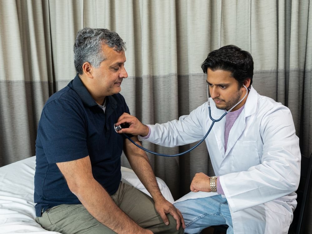 Médico aferindo sinais vitais de paciente em consulta clínica, ilustrando se quem tem arritmia pode fazer endoscopia com segurança.