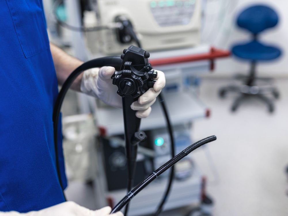 Equipamento de endoscopia sendo preparado por profissional de saúde, etapa inicial de como é feita a colonoscopia em ambiente hospitalar.