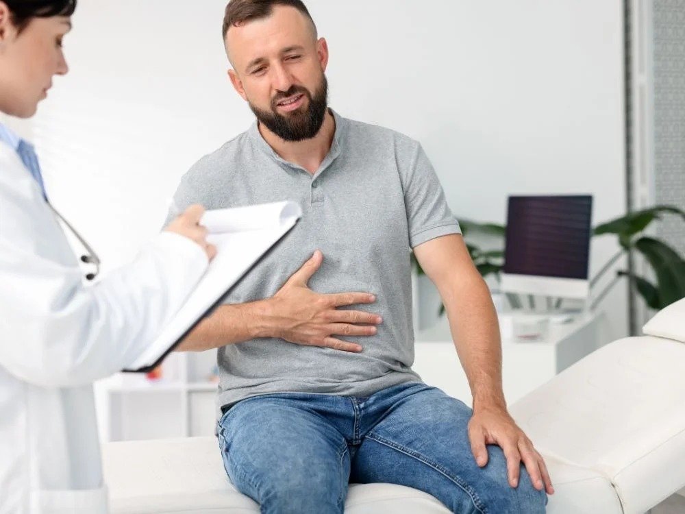 Paciente relatando desconforto ao médico durante avaliação, imagem relacionada a quem tem arritmia pode fazer endoscopia.