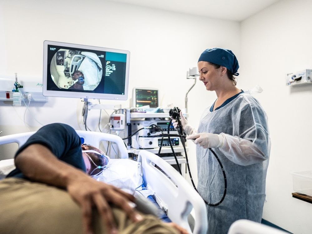 Paciente realizando exame em ambiente hospitalar com equipe médica especializada, cena que ajuda a entender se endoscopia dói ou causa desconforto.