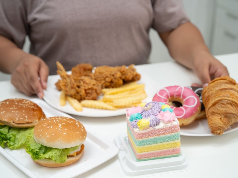 Alimentação com frituras e doces, fator associado ao refluxo em adultos e ao aumento da acidez e desconforto digestivo.