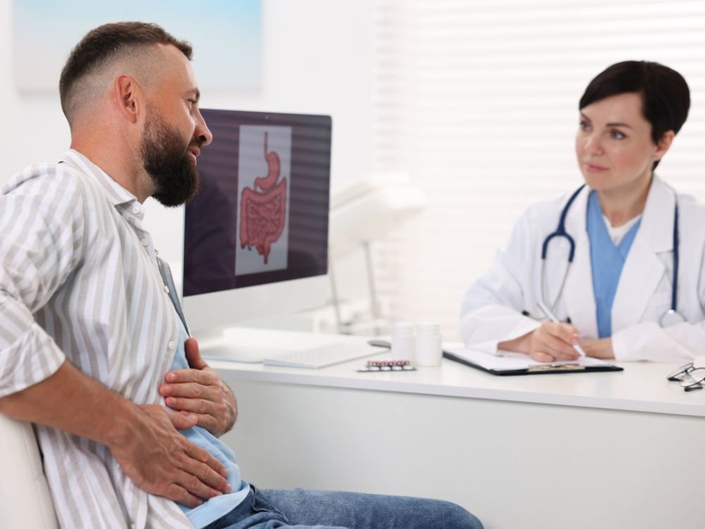 Médico gastroenterologista explicando o tratamento da infecção por Clostridioides (Clostridium) difficile para um paciente no consultório da Clínica Gástrica Usuy.